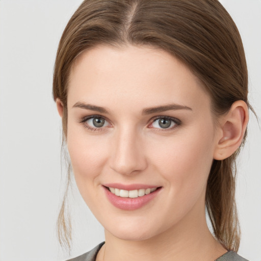 Joyful white young-adult female with medium  brown hair and grey eyes