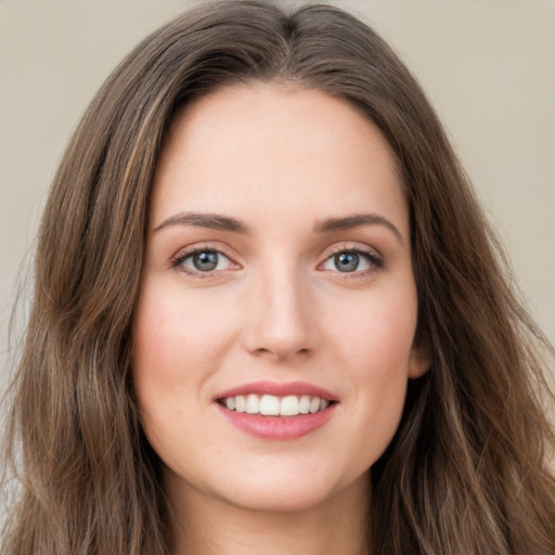 Joyful white young-adult female with long  brown hair and green eyes