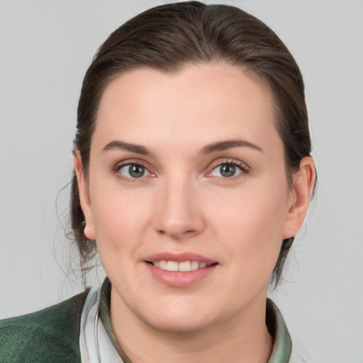 Joyful white young-adult female with medium  brown hair and green eyes