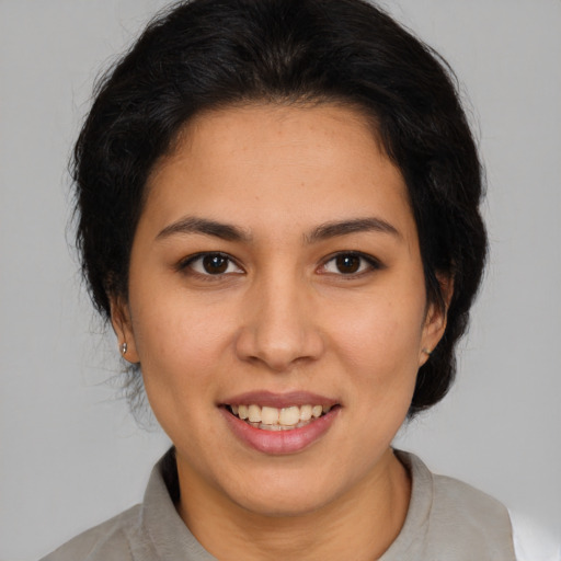 Joyful latino young-adult female with medium  brown hair and brown eyes