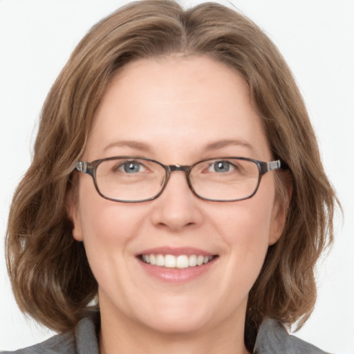 Joyful white adult female with medium  brown hair and blue eyes