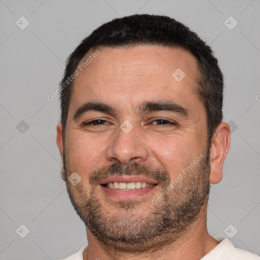 Joyful white adult male with short  black hair and brown eyes