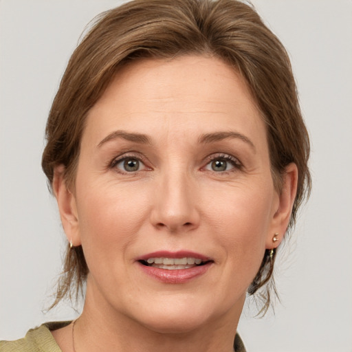 Joyful white adult female with medium  brown hair and grey eyes