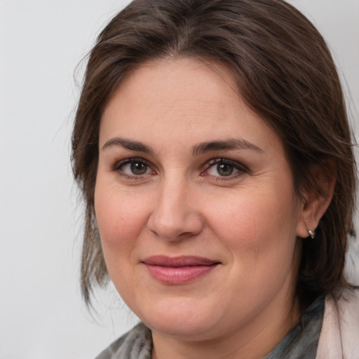 Joyful white adult female with medium  brown hair and grey eyes