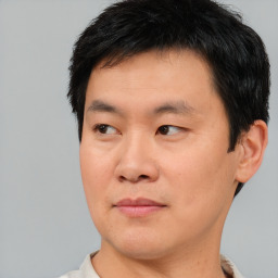 Joyful asian young-adult male with short  brown hair and brown eyes