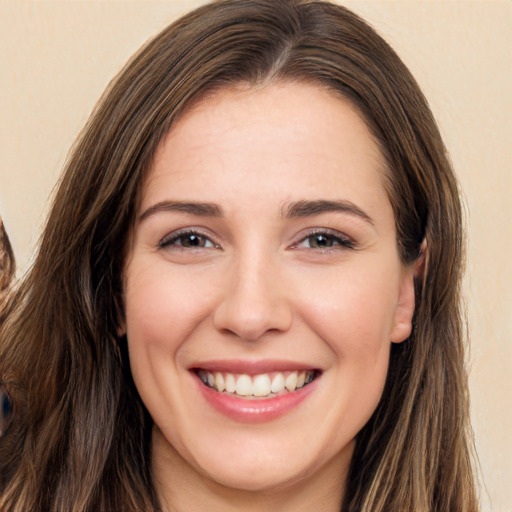 Joyful white young-adult female with long  brown hair and brown eyes