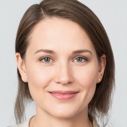 Joyful white young-adult female with medium  brown hair and grey eyes