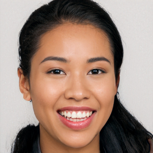 Joyful latino young-adult female with long  brown hair and brown eyes