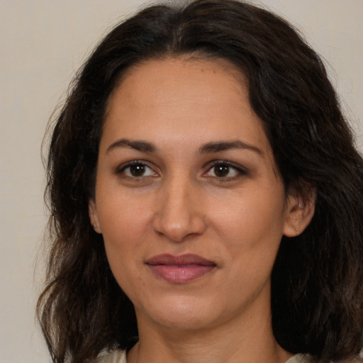 Joyful latino adult female with medium  brown hair and brown eyes