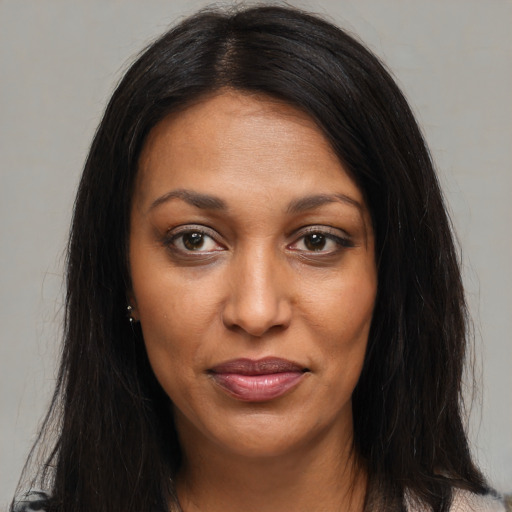 Joyful black young-adult female with long  brown hair and brown eyes