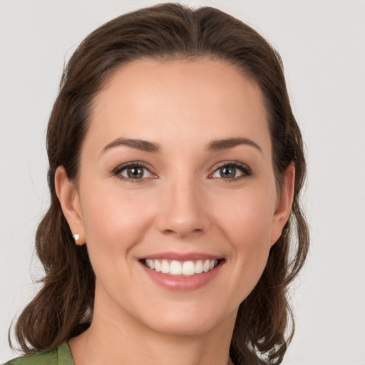 Joyful white young-adult female with medium  brown hair and grey eyes