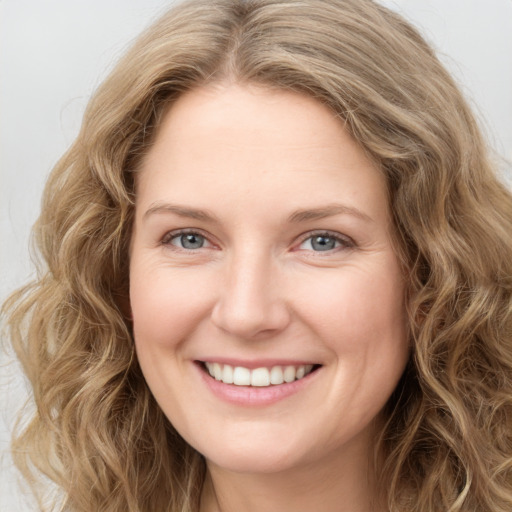 Joyful white young-adult female with long  brown hair and green eyes