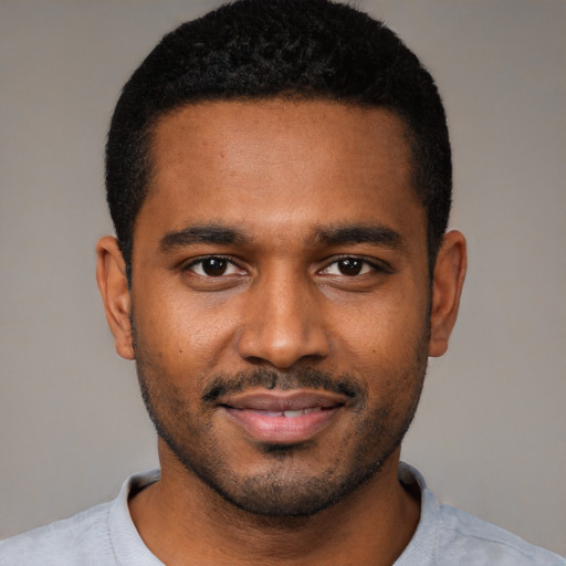 Joyful black young-adult male with short  black hair and brown eyes