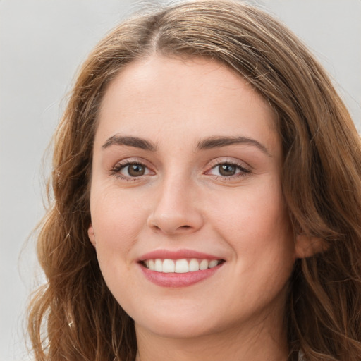 Joyful white young-adult female with long  brown hair and green eyes