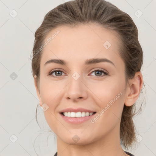 Joyful white young-adult female with medium  brown hair and grey eyes