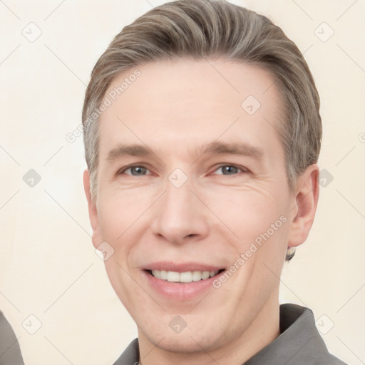 Joyful white adult male with short  brown hair and grey eyes