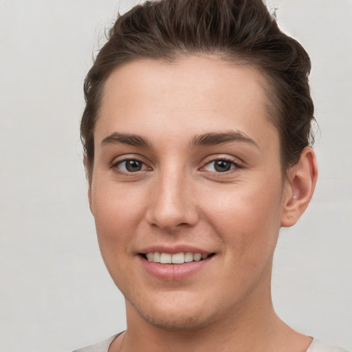 Joyful white young-adult female with short  brown hair and grey eyes