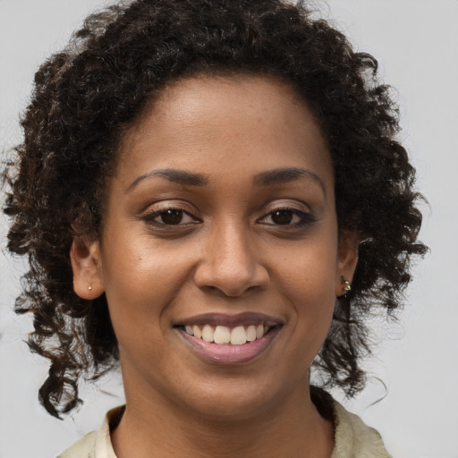 Joyful black young-adult female with medium  brown hair and brown eyes