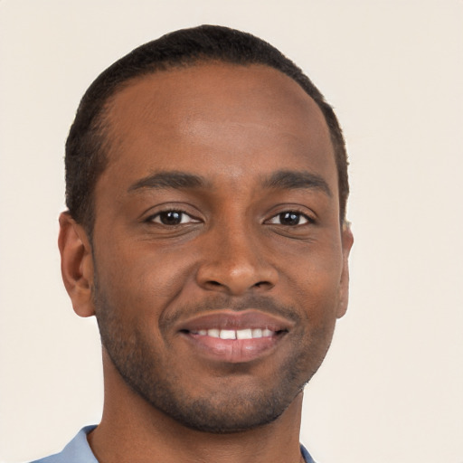 Joyful black young-adult male with short  brown hair and brown eyes