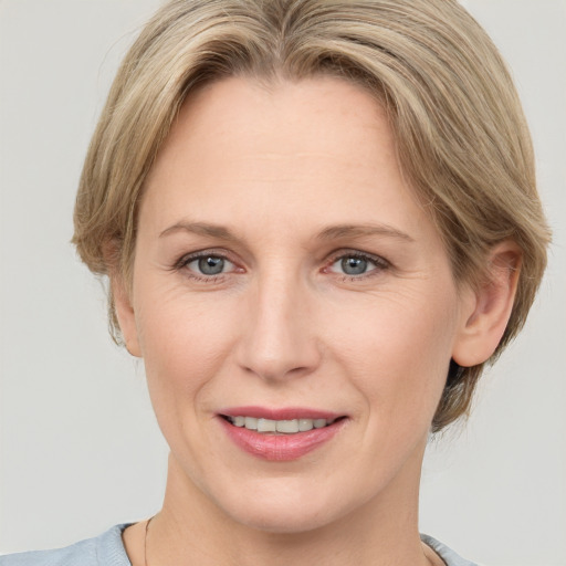 Joyful white adult female with medium  brown hair and grey eyes