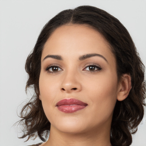 Joyful latino young-adult female with medium  brown hair and brown eyes