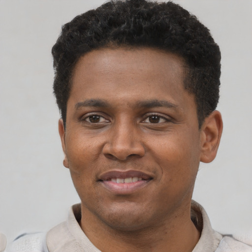Joyful black young-adult male with short  brown hair and brown eyes