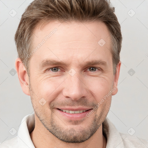 Joyful white adult male with short  brown hair and grey eyes