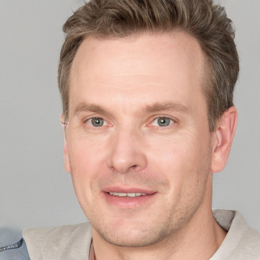 Joyful white adult male with short  brown hair and grey eyes