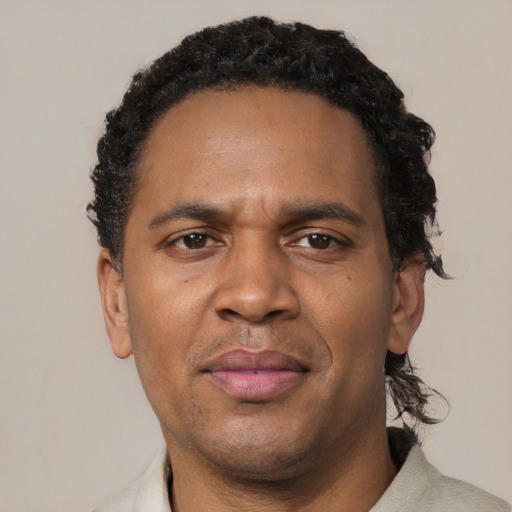 Joyful black adult male with short  brown hair and brown eyes