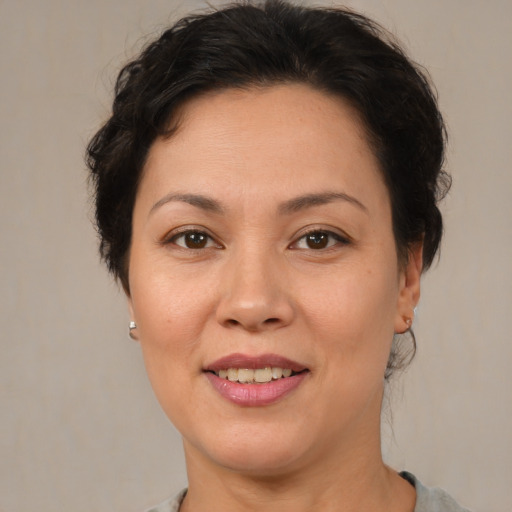 Joyful latino adult female with medium  brown hair and brown eyes