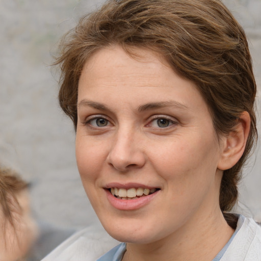 Joyful white adult female with medium  brown hair and brown eyes