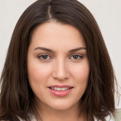 Joyful white young-adult female with long  brown hair and brown eyes