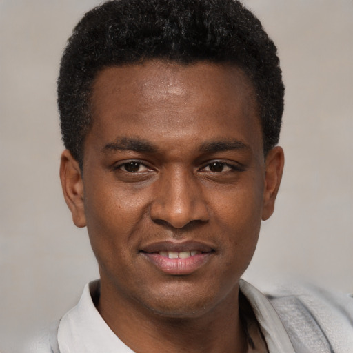 Joyful black young-adult male with short  brown hair and brown eyes