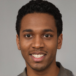 Joyful black young-adult male with short  black hair and brown eyes