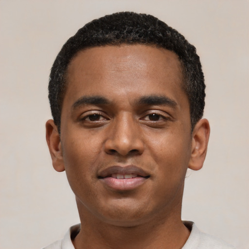 Joyful black young-adult male with short  black hair and brown eyes