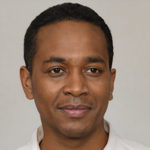 Joyful black young-adult male with short  black hair and brown eyes