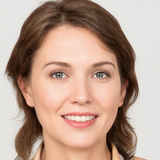 Joyful white young-adult female with medium  brown hair and grey eyes