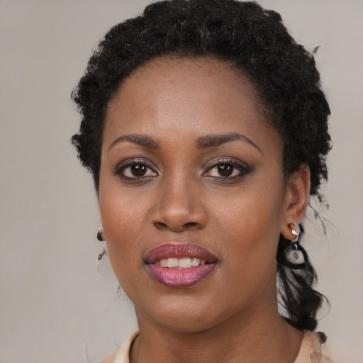 Joyful black young-adult female with long  brown hair and brown eyes