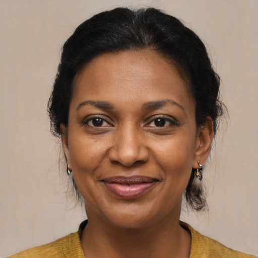 Joyful black adult female with medium  brown hair and brown eyes