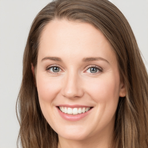 Joyful white young-adult female with long  brown hair and grey eyes