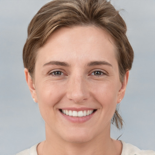 Joyful white young-adult female with short  brown hair and grey eyes