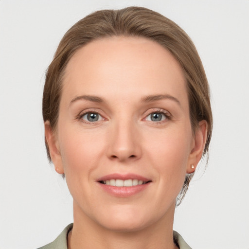 Joyful white young-adult female with medium  brown hair and grey eyes