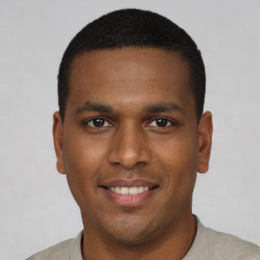 Joyful black young-adult male with short  black hair and brown eyes