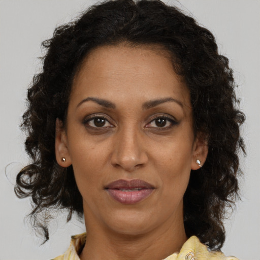 Joyful black adult female with medium  brown hair and brown eyes