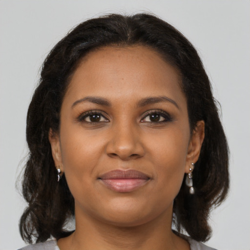 Joyful black young-adult female with medium  brown hair and brown eyes