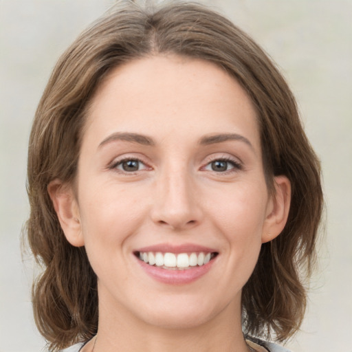 Joyful white young-adult female with medium  brown hair and green eyes