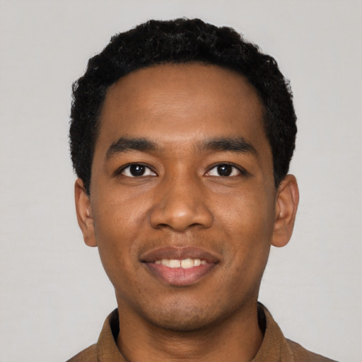Joyful black young-adult male with short  black hair and brown eyes