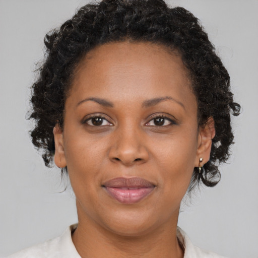 Joyful black adult female with short  brown hair and brown eyes