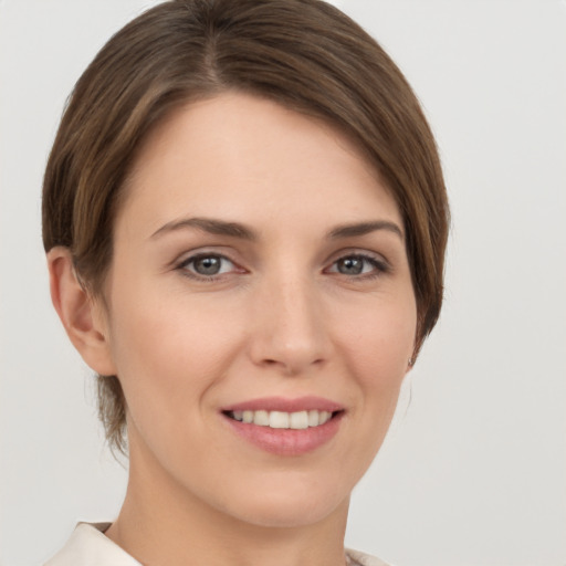 Joyful white young-adult female with short  brown hair and grey eyes