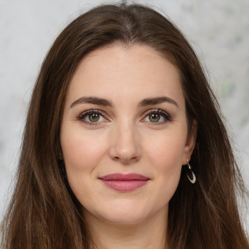 Joyful white young-adult female with long  brown hair and green eyes